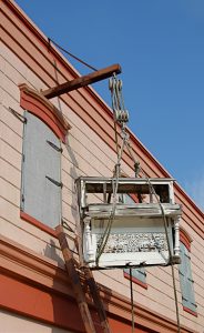 Antique piano hanging from rooftop of New Orleans building
